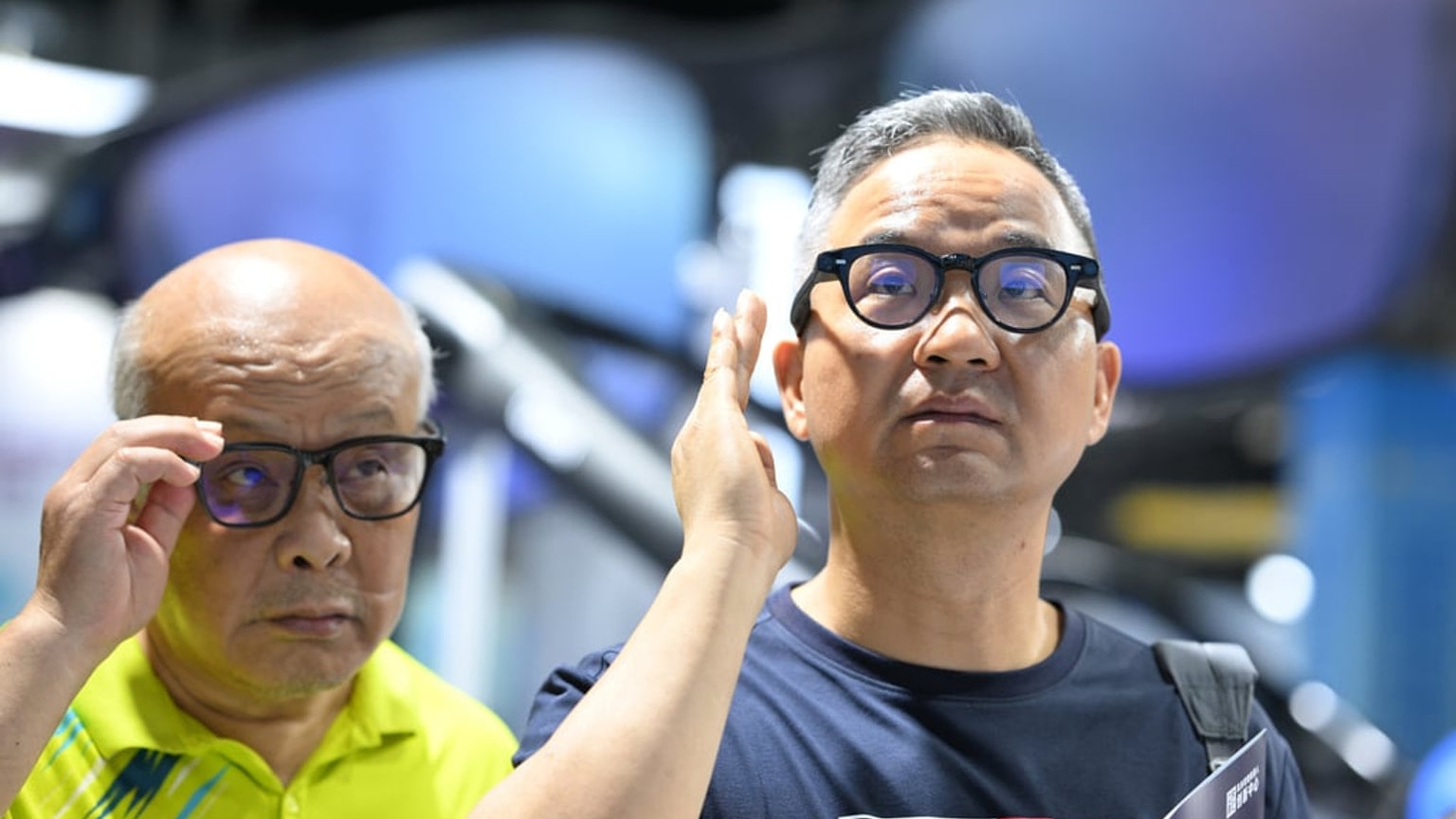 Visitors test smart glasses at an artificial intelligence industry event in Nanjing, according to the source caption.